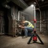 LED Tripod Work Light Hire London | Milwaukee Single-Head Site Light 9 Technician using Milwaukee M12 cordless tripod stand light while servicing boiler in dark basement - LED Tripod Site Work Light