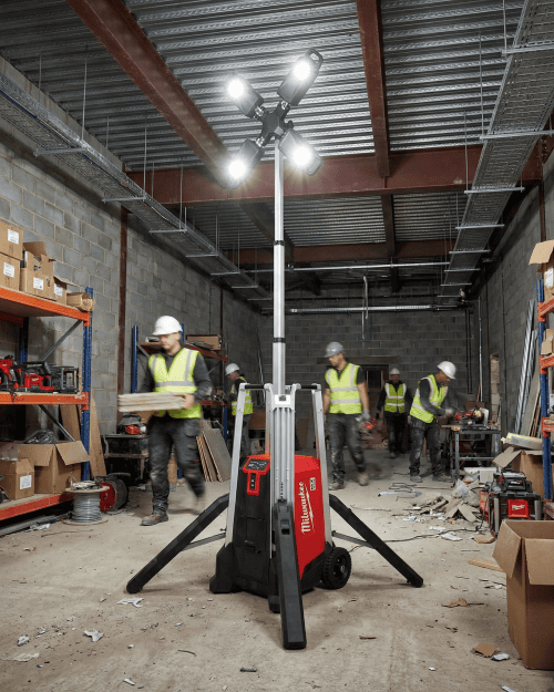 Milwaukee MX FUEL LED lighting tower illuminating an indoor construction site with workers and materials - Lighting Tower Hire London | Powerful Milwaukee MX FUEL 3.1m Work Tower 27,000 Lumens