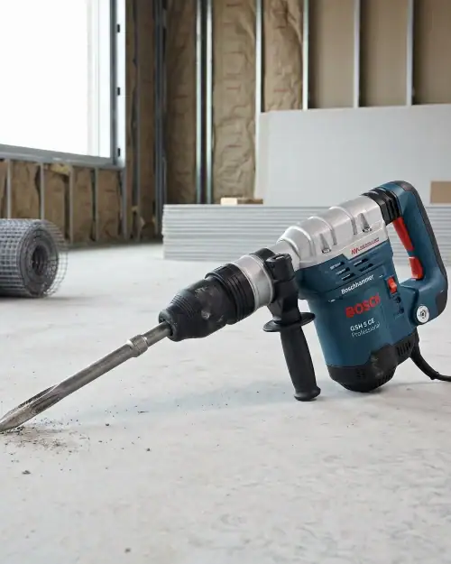Light breaker hire London SDS Max demolition hammer breaking up concrete floor on construction site