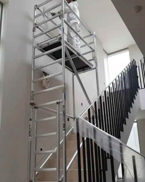 Stairwell scaffold tower hire in use for painting and decorating above a residential staircase