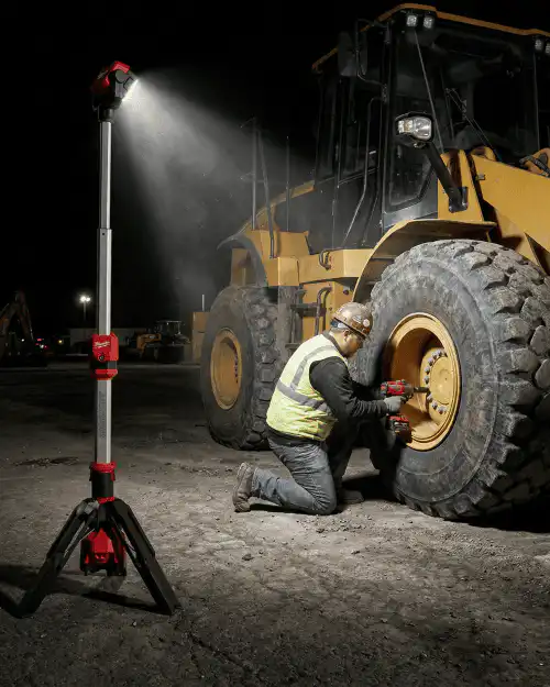 LED Tripod Work Light Hire London | Milwaukee Single-Head Site Light 6 Milwaukee M12 cordless stand light illuminating night-time repair on construction vehicle