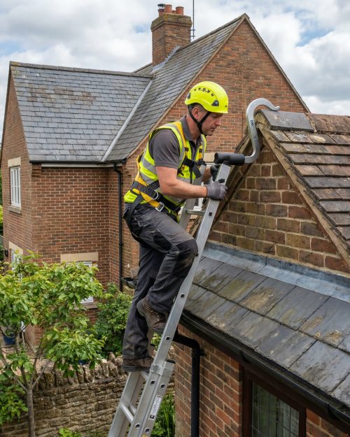 Roof ladder securely positioned on a pitched roof for safe roof access and inspection work.