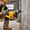 SDS Plus Hammer Drill Hire London | Rotary Hammer for Concrete and Masonry 12 Worker in hard hat drilling into masonry block wall with DeWalt SDS Plus rotary hammer drill on construction site