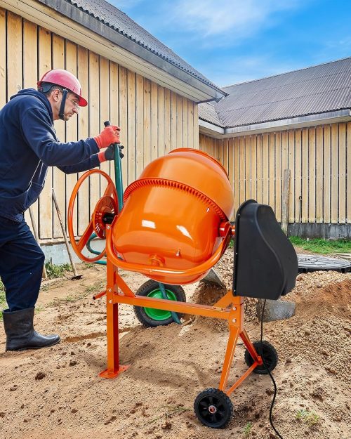 Large orange electric cement mixer with handwheel on tall stand and transport wheels, clean 140L drum in studio view - Cement Mixer Hire London