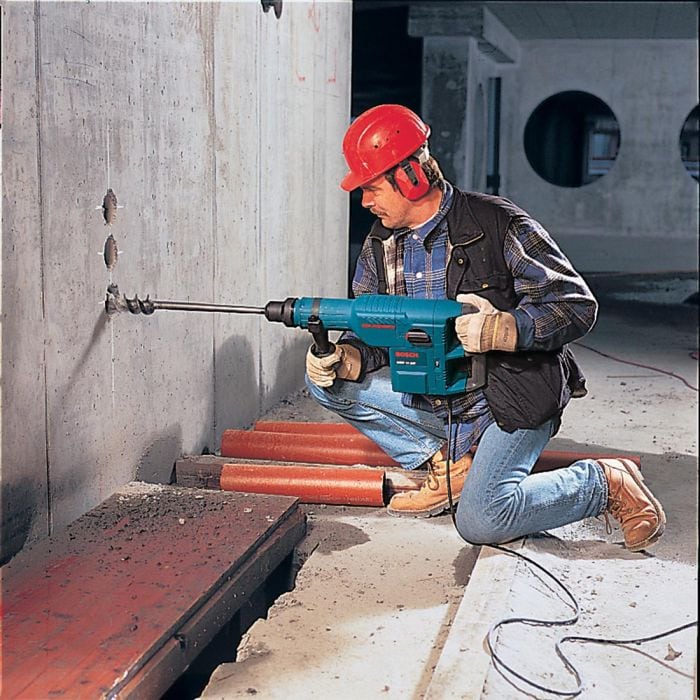 Rotary Hammer Hire London | Bosch GBH 11 DE SDS Max Combi Hammer (11kg) 2 Worker in hard hat using Bosch GBH 11 DE rotary hammer to drill through concrete wall on demolition site