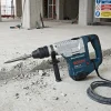 Medium Breaker Hire London | Bosch GSH 11 E SDS Max Demolition Hammer 12 Bosch GSH 11 E Professional SDS Max medium breaker hire on rubble-strewn construction site floor with safety signs visible